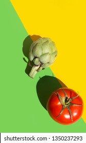 Ripe Artichoke Red Tomato On Duotone Yellow Green Background. Hard Light Harsh Shadows. Trendy Funky Minimalist Style. Creative Food Poster Banner. Healthy Plant Based Diet Mediterranean Cuisine