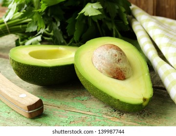 Ripe Avocado Cut In Half On A Wooden Table