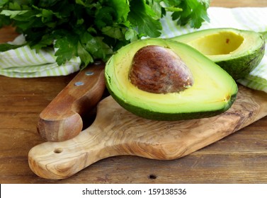 Ripe Avocado Cut In Half On A Wooden Table