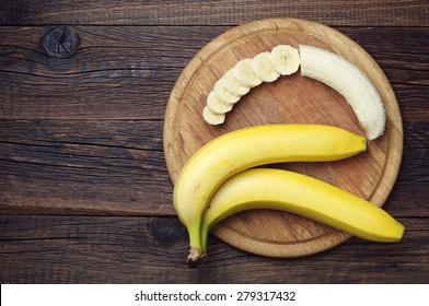 Ripe Bananas And A Sliced On Wooden Cutting Board, Top View