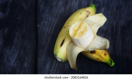 Ripe bananas that have been bitten on a wooden table