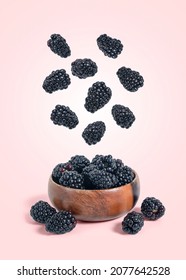 Ripe Blackberries Falling Into A Wooden Bowl