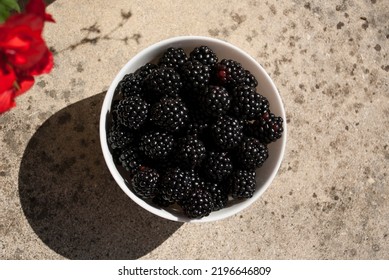 Ripe Blackberries In White Plate With Long Shadows On Table. Fruit On A Table Close Up. Flat Lay Styling, Top View