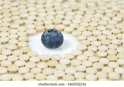 Ripe Blueberries Surrounded By Pills On All Sides. Concept: Natural Vitamins. Close Up.