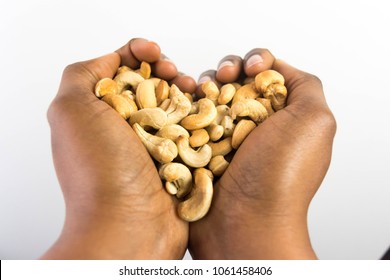 Ripe Cashew Nuts In African American Dark Brown Skin Woman's Hands Forming Heart Shape For Love Nuts Food Diet Concept Isolated On White Background 