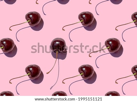 Ripe cherry berries seamless pattern on pink background. Close up.