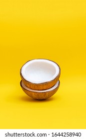 Ripe coconut nuts on bright yellow background, copy space