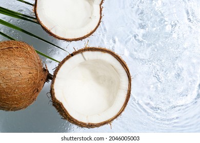 Ripe coconuts on light background with water splashes