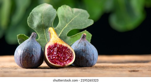 Ripe fig fruits with leaf close-up. Beautiful sweet fresh organic figs on a wooden table. Label design. Healthy vegan food - Shutterstock ID 2195265323