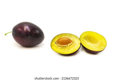 Ripe fresh organic plum whole and cut in half isolated on white background. - Shutterstock ID 2136672323