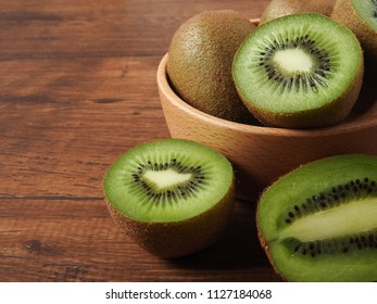 Ripe fresh oval kiwifruit on a wood background. It has fibrous, bright green flesh and edible black seeds. A sweet and unique taste.It is a natural, healthy and nutritious food.With copy space.