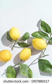 Ripe fresh Sicilian lemons with green leaves on white backgroundwith copy space for grafic design. Organic citrus fruits with bright sunlight. Healthy food concept
