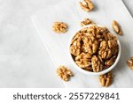 Ripe and fresh walnut kernels in bowl or burlap sack without shell on rustic table, healthy nut food for brain