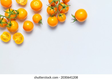 Ripe Fresh Yellow Orange Tomatoes With Green Tails On Light Gray Background Flat Lay Top View. Cherry Tomatoes. Vegetables, Healthy Vegan Organic Food, Harvest Concept Tomatoes Pattern Layout Cooking