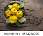 Ripe golden yellow quince fruits bowl Organic fruits on old wooden table. Top view.