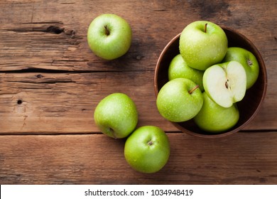 Ripe green apples in a wooden bowl on an old rustic table. Useful fruits on wooden background. Top view with copy space - Powered by Shutterstock