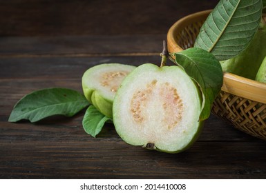 Ripe Guava Cut In Half, Four Green Leaves On An Old Wooden Board.