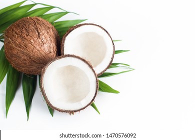 Ripe half cut coconut with green leaves on a white background. Isolated concept. 