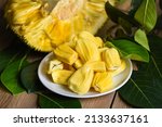 Ripe jackfruit peeled tropical fruit fresh from jackfruit tree, jackfruit on white plate with leaf on wooden background