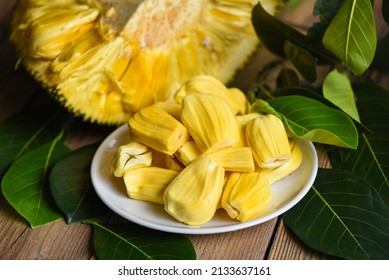 Ripe jackfruit peeled tropical fruit fresh from jackfruit tree, jackfruit on white plate with leaf on wooden background
