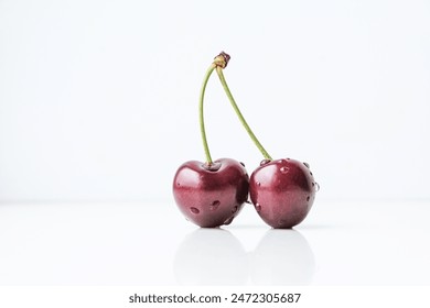 Ripe juicy cherries with water droplets on a light colored background. - Powered by Shutterstock