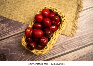 Ripe juicy cherries in a wicker basket on a background of homespun fabric with a rough texture. Close up. - Shutterstock ID 1783392881