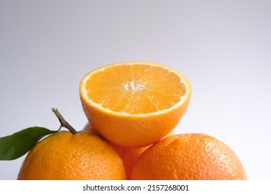 ripe and juicy orange. fresh orange cut in half on a background of oranges with leaves