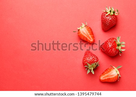 Ripe juicy strawberries on a red background. pattern. Creative summer background composition with strawberry. Minimal fruit concept.