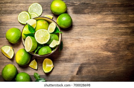 Ripe Limes In A Bowl. On A Wooden Table.