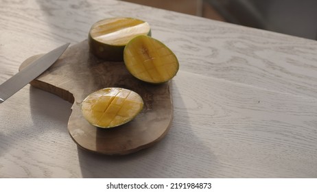 Ripe Mango On Olive Board With Knife On White Oak Table