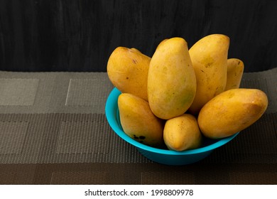 Ripe Manila Mangoes On A Blue Plate With A Black Background