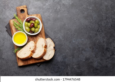 Ripe olives, olive oil and ciabatta bread. Top view flat lay with copy space - Powered by Shutterstock