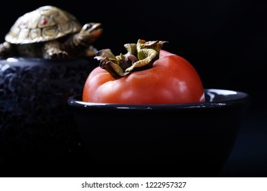 Ripe Orange Persimmon Fruit On A Black Plate On A Black Background, Buddhist Symbols, Chusok Harvest Festival