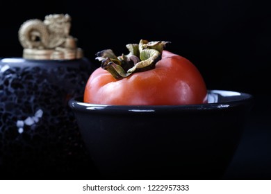 Ripe Orange Persimmon Fruit On A Black Plate On A Black Background, Buddhist Symbols, Chusok Harvest Festival