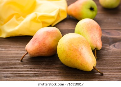 Ripe pears and napkin on a wooden table
