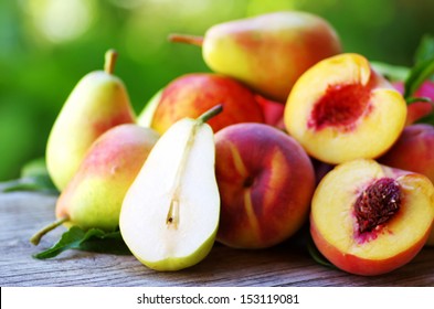 Ripe pears and peaches on table