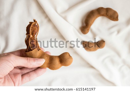 Ripe peeled tamarind in female hand