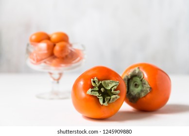 Ripe persimmons on a light background