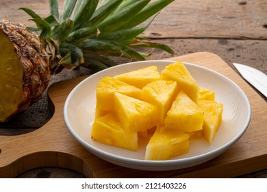 Ripe pineapple slice on white plate on a wooden table - Powered by Shutterstock