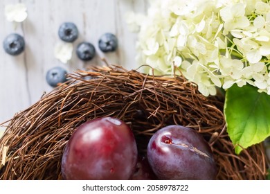 Ripe Plums In A Vine Cinnamon On A Wooden Background. Hydrangea Flowers And Blueberries Lie Side By Side. Close-up. Selective Focus