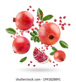 A ripe pomegranate with seeds and leaves flying in the air. Background with pomegranate fruit. Pomegranate fruit on a white background. - Powered by Shutterstock