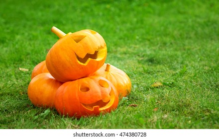 Ripe Pumpkins For Halloween On Green Grass Background