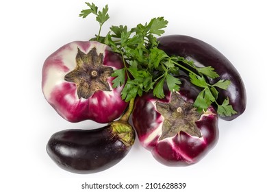 Ripe purple eggplants Helios variety and ordinary eggplants with fresh parsley twigs on white background, top view