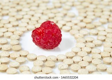 Ripe Raspberries Surrounded By Pills On All Sides. Concept: Natural Vitamins. Close Up.