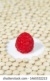 Ripe Raspberries Surrounded By Pills On All Sides. Concept: Natural Vitamins. Close Up.