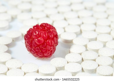 Ripe Raspberries Surrounded By Pills On All Sides. Concept: Natural Vitamins. Close Up.