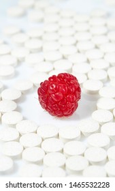 Ripe Raspberries Surrounded By Pills On All Sides. Concept: Natural Vitamins. Close Up.