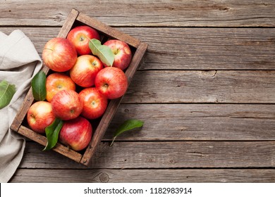 Zralá červená jablka v dřevěné krabici. Pohled shora s prostorem pro text