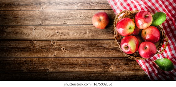 Ripe red apples in wooden box top view on rustic table. Wide apple banner with space for your text