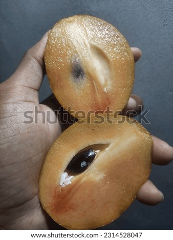 Ripe sapodilla fruit is split into 2 and eaten sweet